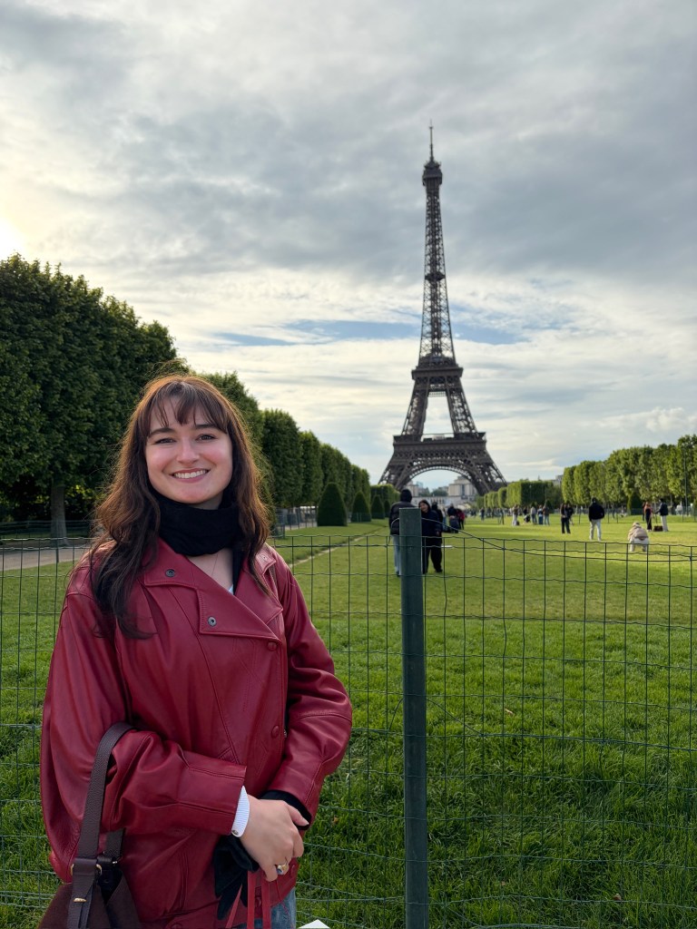 A woman standing in front of the Eiffel Tower.